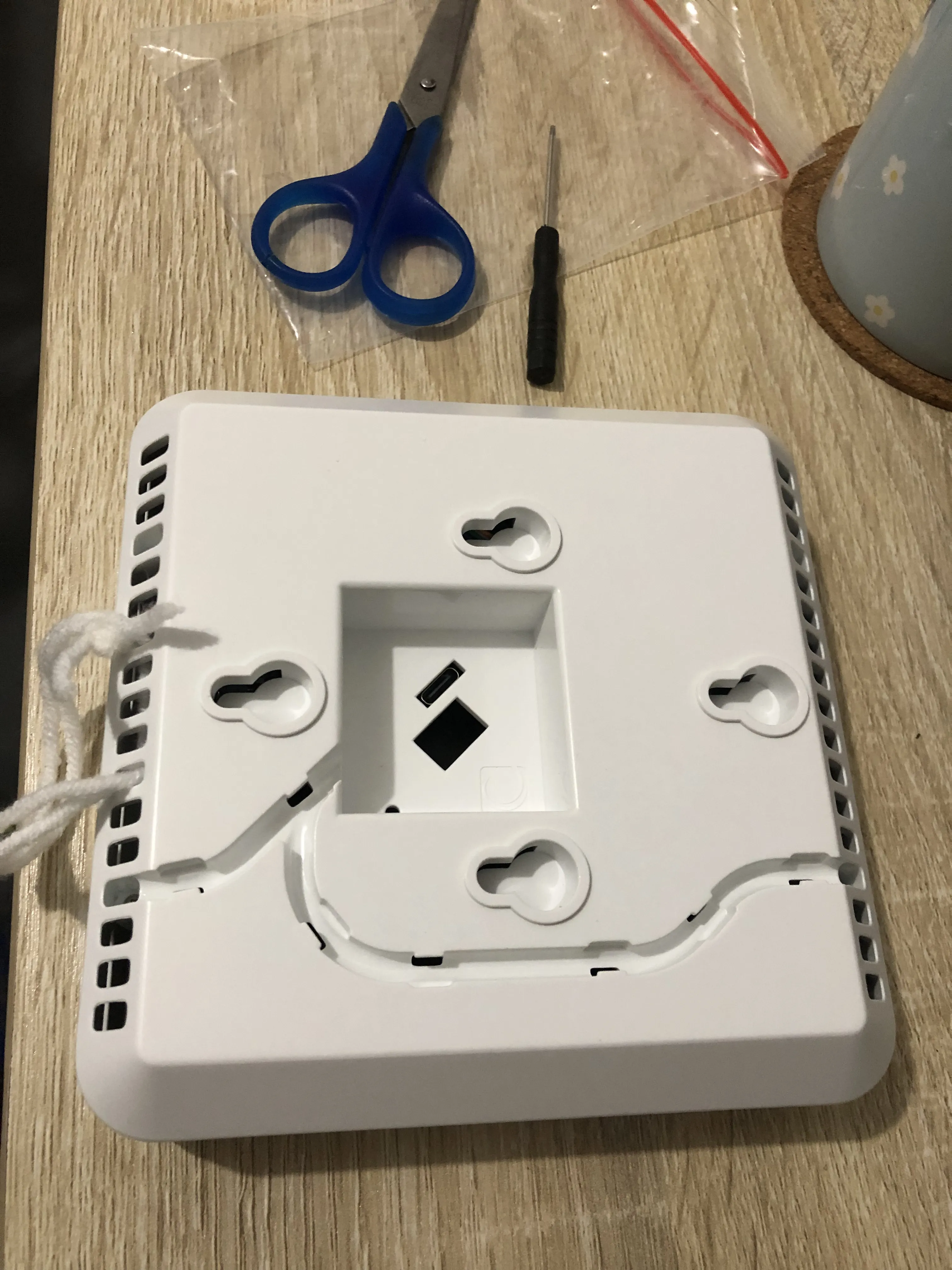 Back side view of AirGradient. To avoid punching a hole in the wall, I'm using knitting thread to hang the unit.