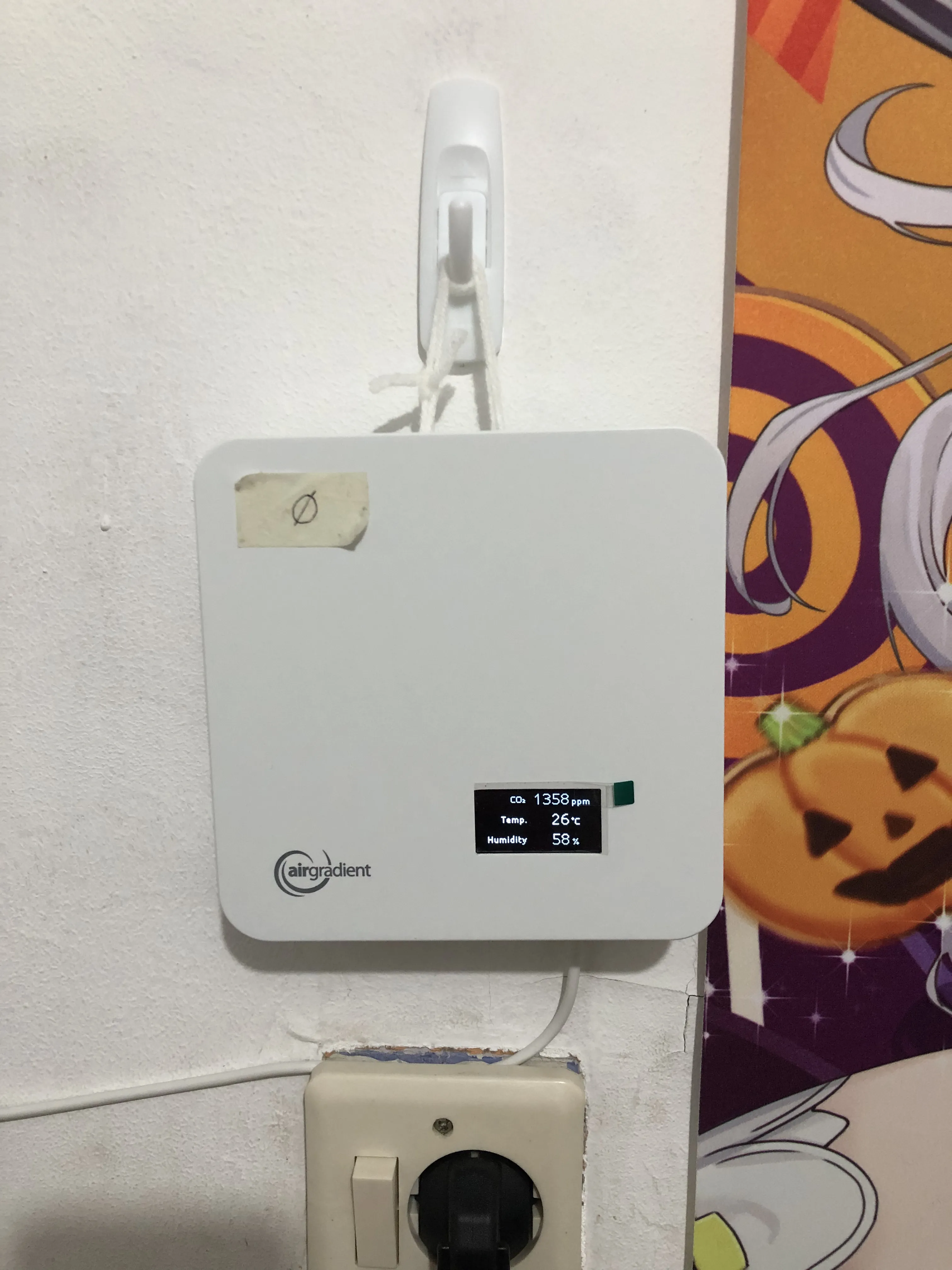 AirGradient in action. Yes, the CO2 is high, my room has bad air circulation. Yes, the electric socket below has slight openings and is hazardous, I need to fix it eventually.